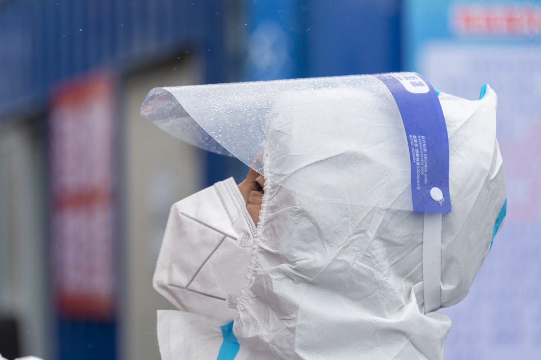 在哈爾濱繞城高速公路長江路收費站入口，志愿者在雨雪天氣中對抵返哈人員進行查驗（3月14日攝）。