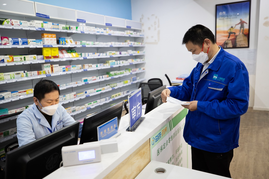 4月5日，在上藥云健康益藥藥房，送貨員葉義飛（右）把處方交給醫(yī)師審核。