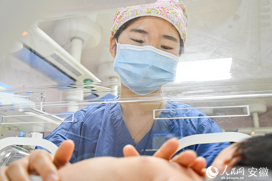 “臨時媽媽”仔細安撫著新生兒。人民網 周坤攝