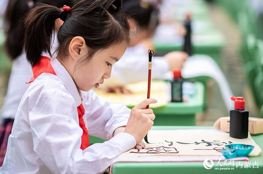 呼和浩特市玉泉區(qū)恒昌店巷小學(xué)學(xué)生在參加漢字書(shū)寫(xiě)大賽軟筆項(xiàng)目的比賽。丁根厚攝