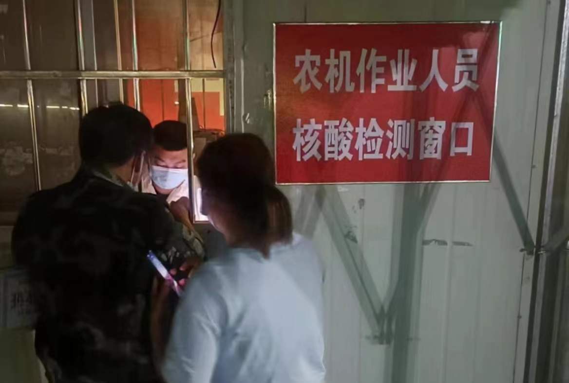 高速口的跨區作業農機接待服務站24小時不間斷接待跨區農機及人員。圖為深夜為農機手做核酸及抗原檢測。徐水區農業農村局供圖